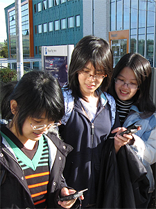 Pupils from Mahidol Wittayanusorn School, Thailand, try out a location-based mobile phone game developed by InfoLab21's Dr Paul Coulton