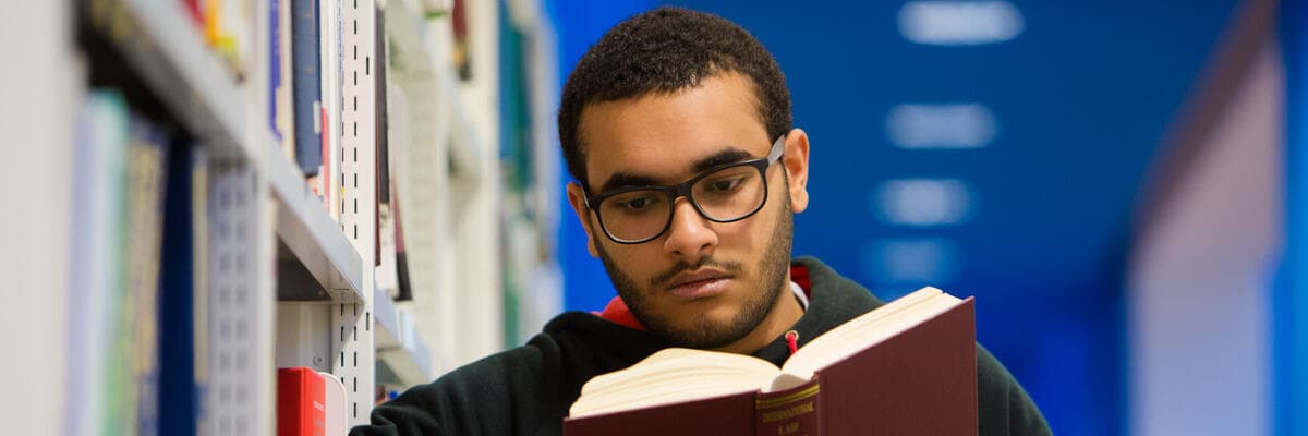 law student reading book in library