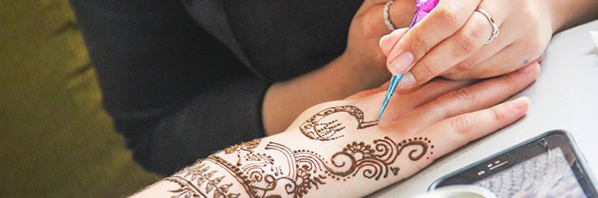 Girl drawing a henna tattoo