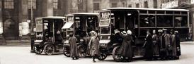 Fleet of battery-powered buses pick up passengers in Market Square for the Caton Road Munitions Works in 1917.