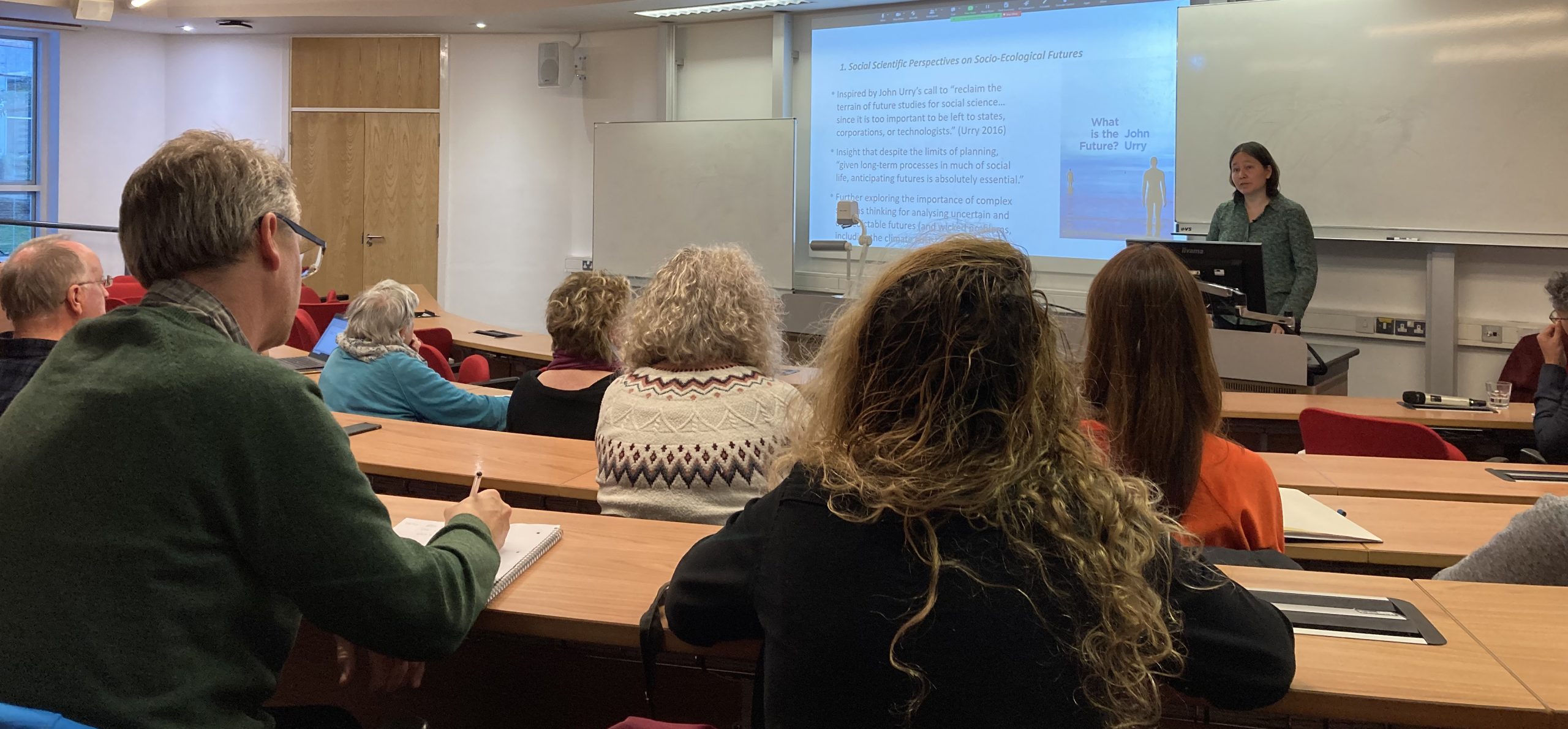 AliceMahLecture People in a lecture theatre, with the speaker Alice Mah at the front.