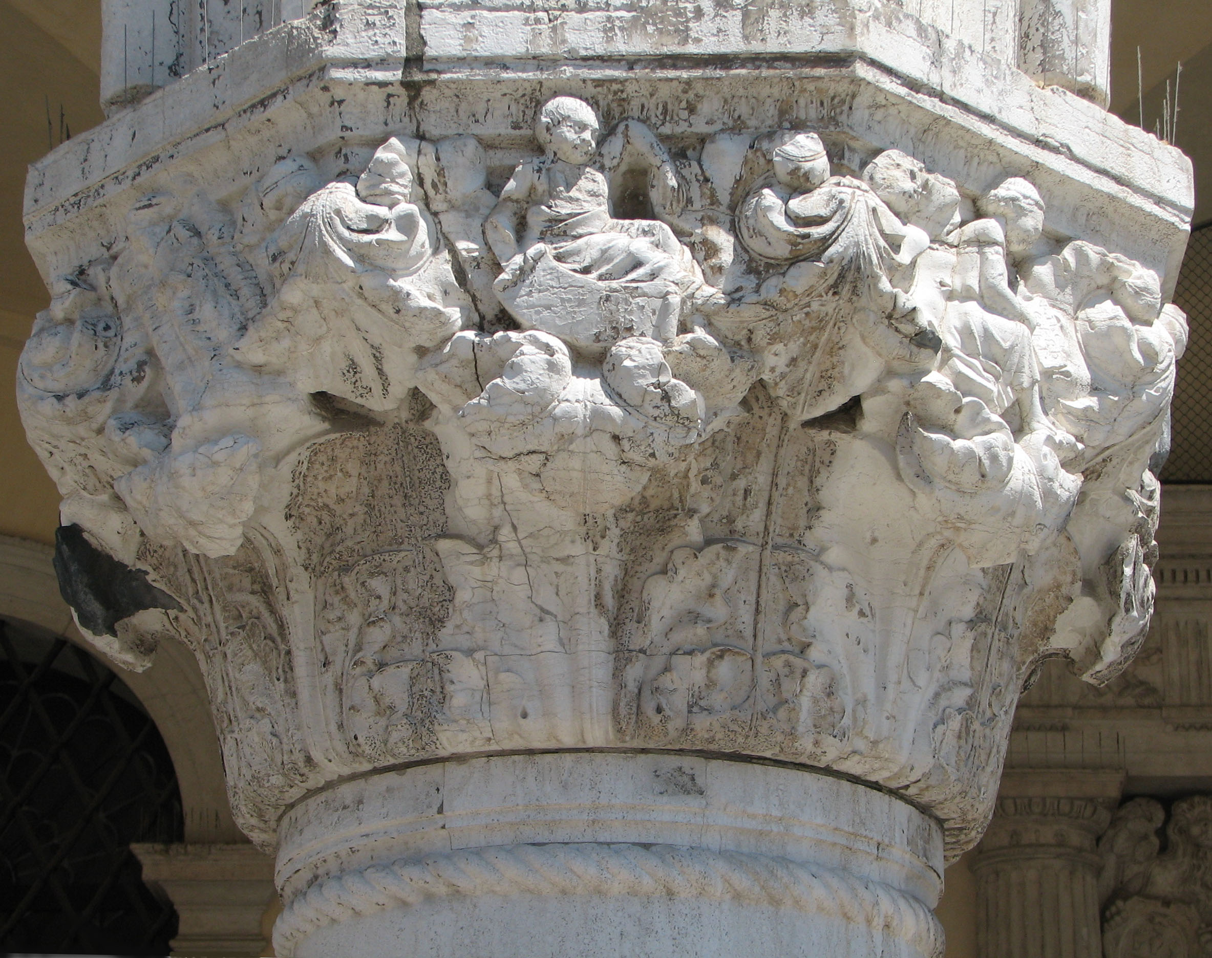 Detail of 22nd capital in its current state Death, side 8, left; Infancy, side 1, centre; Childhood, side 2, right