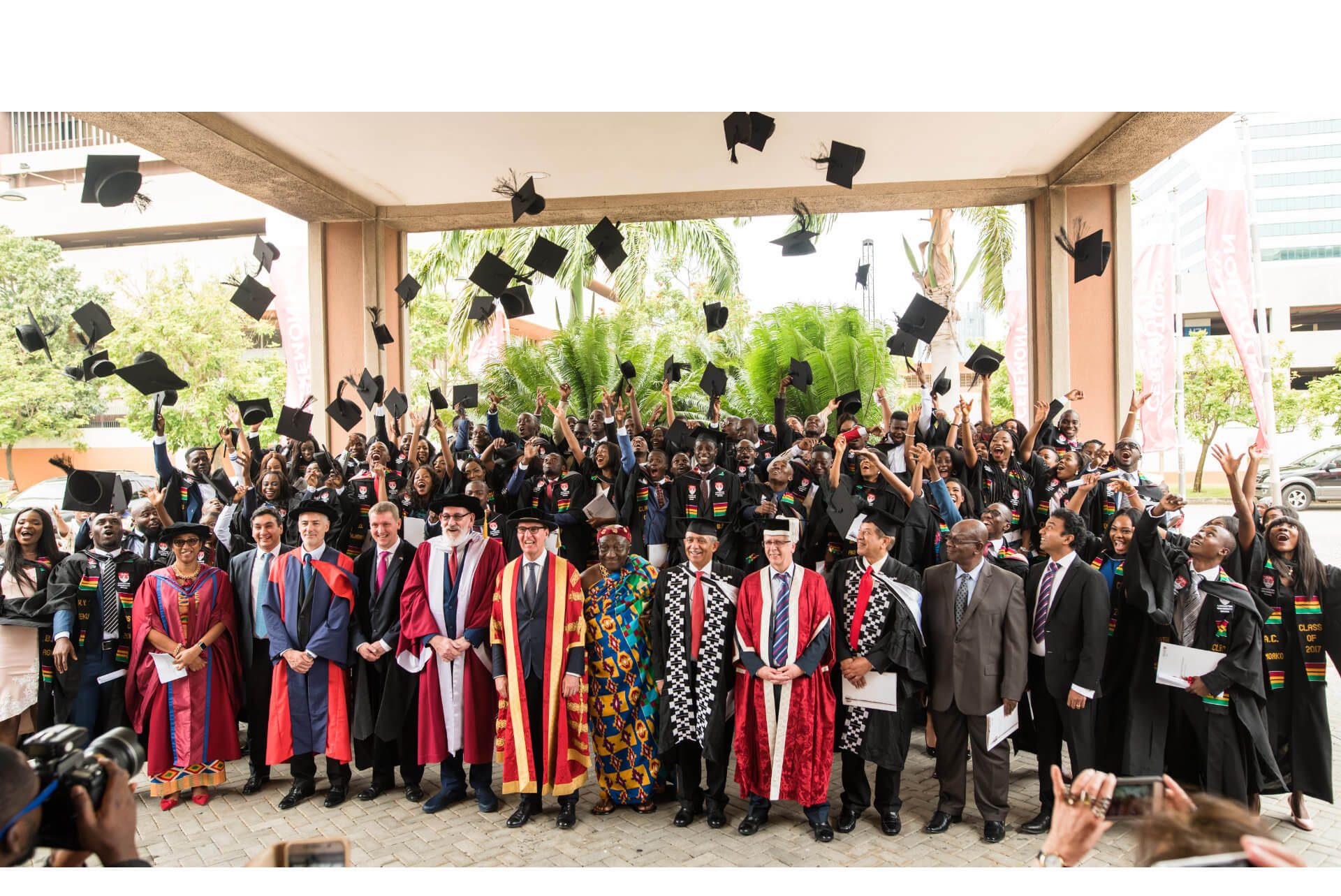 A graduation ceremony at the Ghana campus sees students throwing their caps into the air.