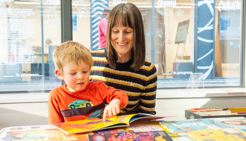 A young child reading in the library