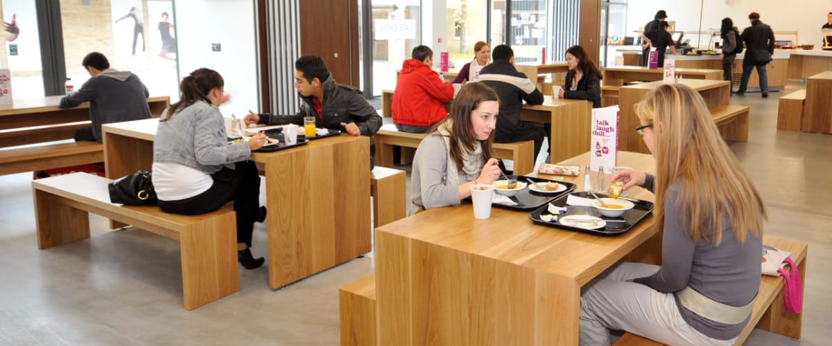 Students sit in a diner, eating and talking.