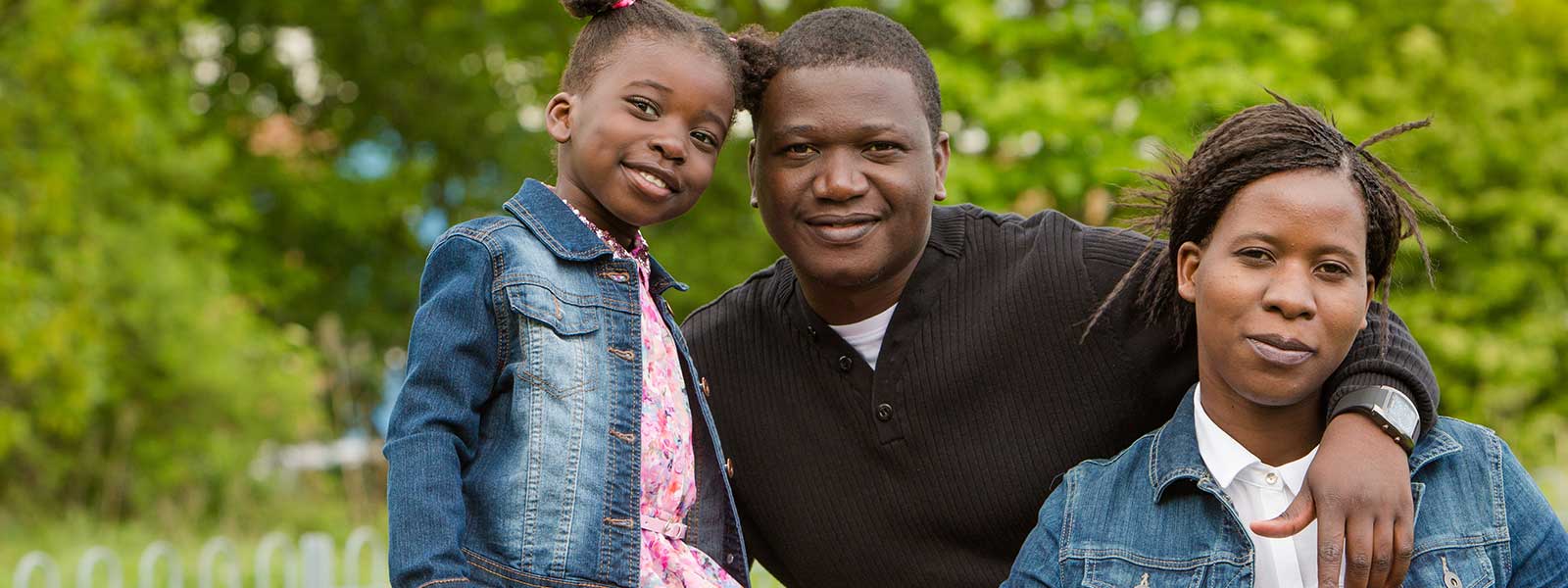 Parents and a child in green surroundings