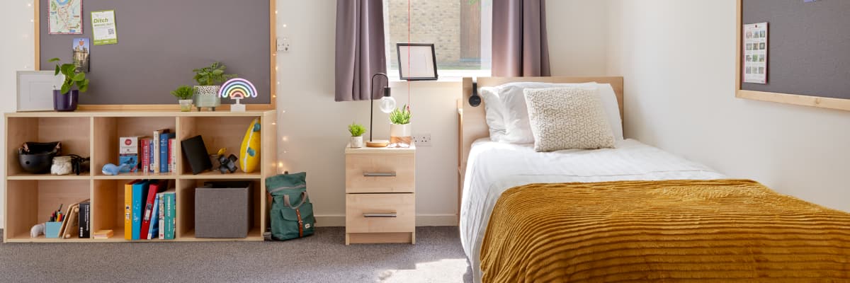 An adapted bedroom with a bed on the right and a book case on the left.