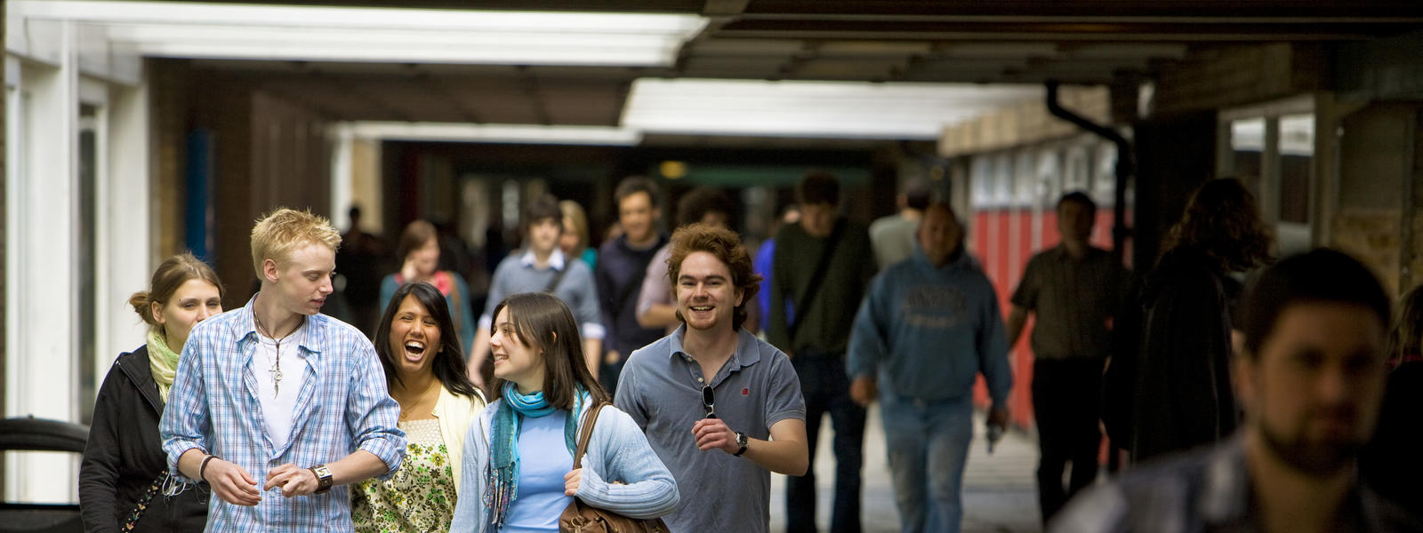 Students walking out on campus smiling and talking