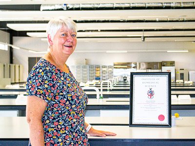 Dr Fiona Benson standing in front of a fume cupboard.