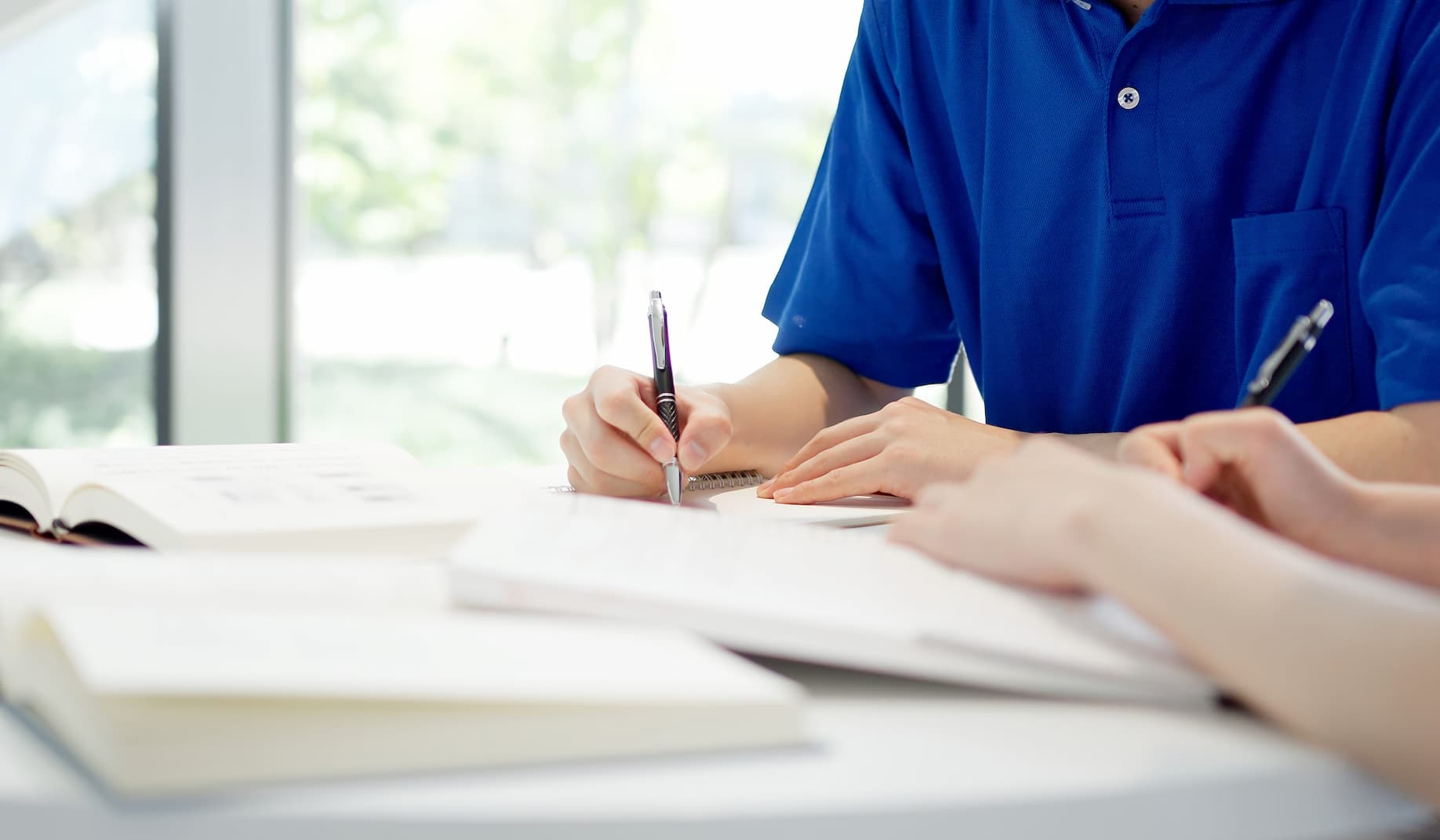 A person's hand writing in a notebook