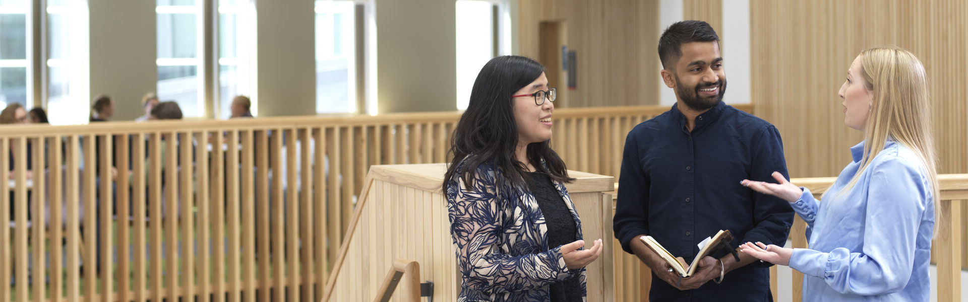 Two women sat in a meeting talking to one another