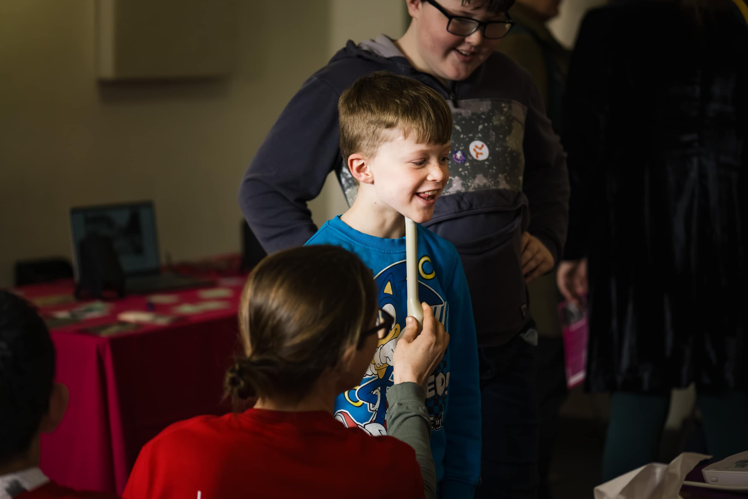 a researcher holds and ultra sound to a boys chin as he speaks