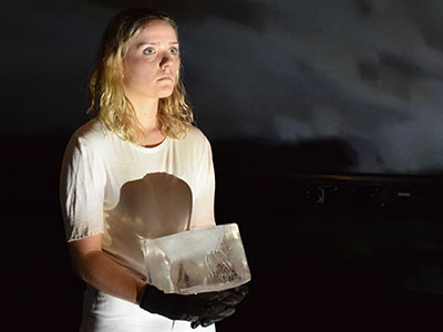 a girl in a white dress holds a block of ice