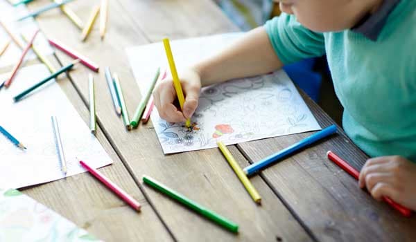 Child colouring with pencils