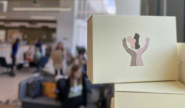  photo of a pile of hope boxes with people blurred in the background