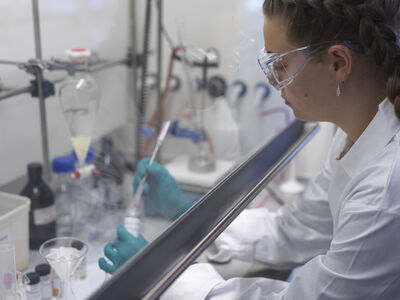 A student working under a fume hood.