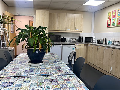 Kitchen with view of cupboards and dining table with plant on top.