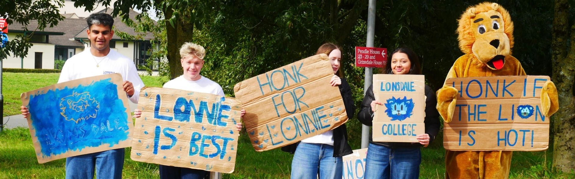 Lonsdale students with signs on arrivals