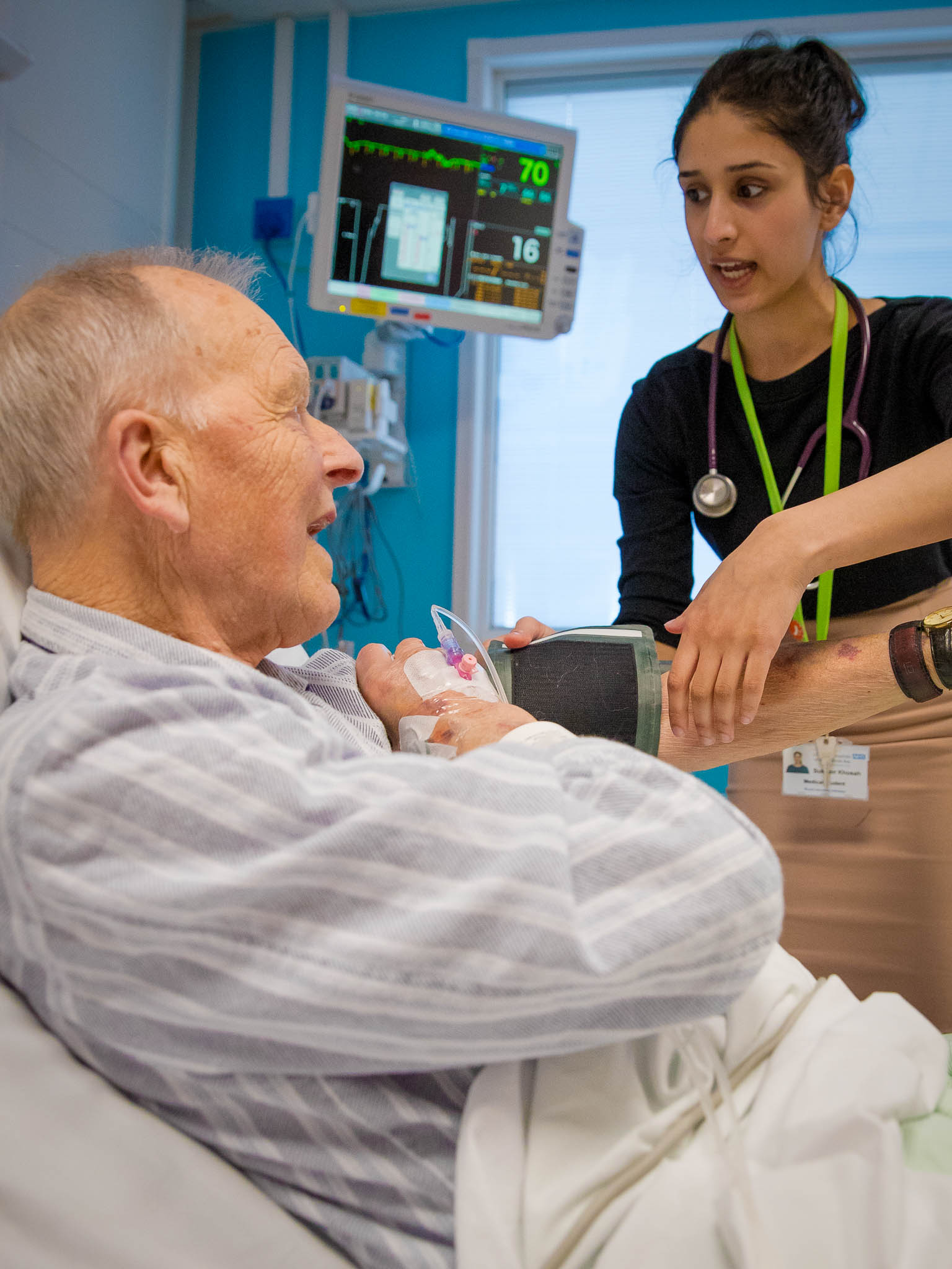 A geriatric patient in bed being interviewed by a junior doctor