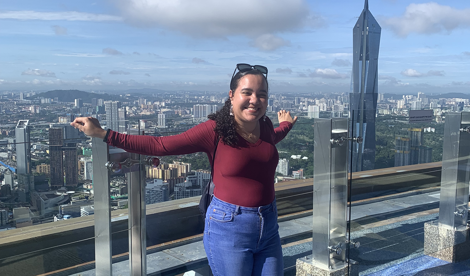 Student Lyea poses in front of Malaysia skyline