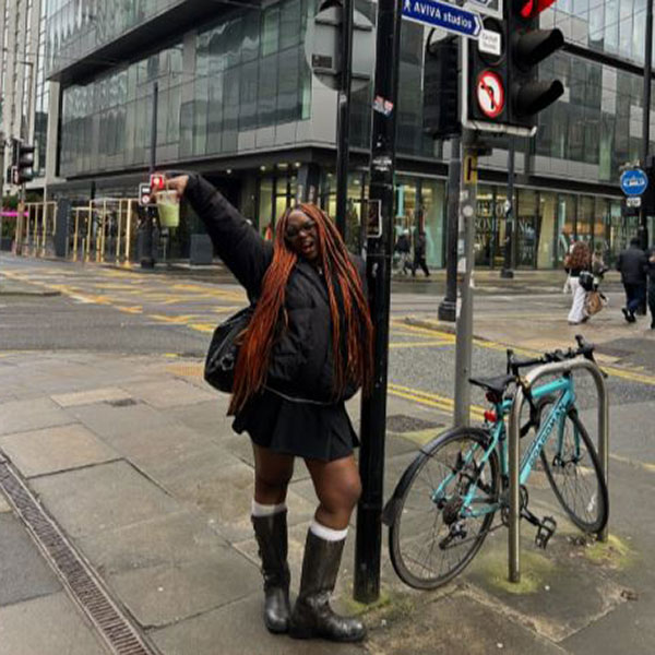 Student leant on signpost