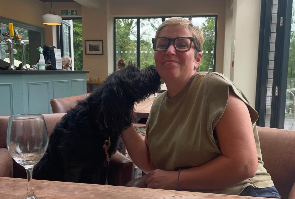 Martha's mum with their dog in a restaurant.