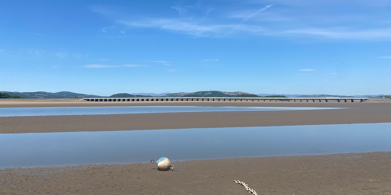 Low tide at Arnside beach with a blue sky. 