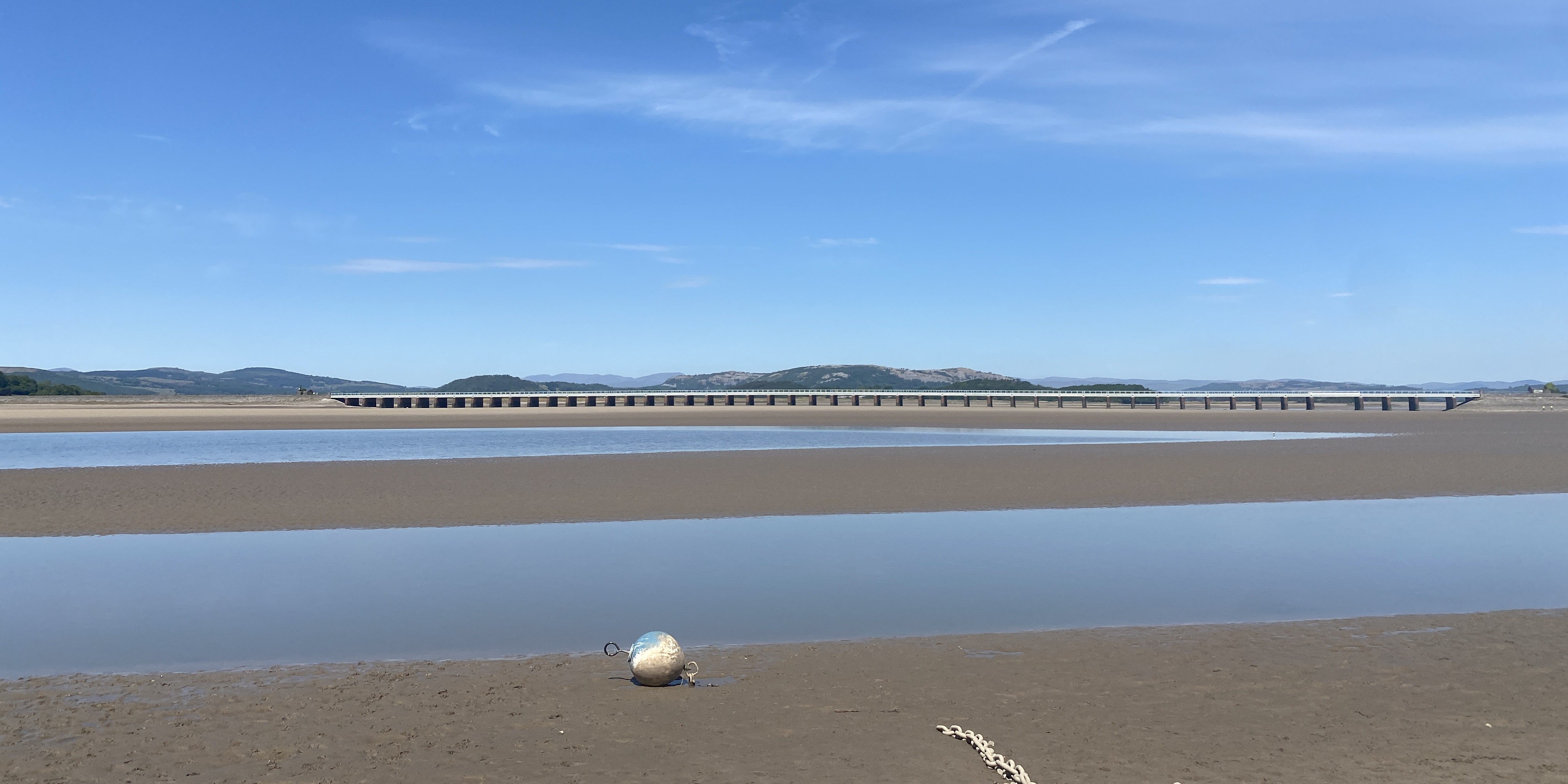 Low tide at Arnside beach with a blue sky. 