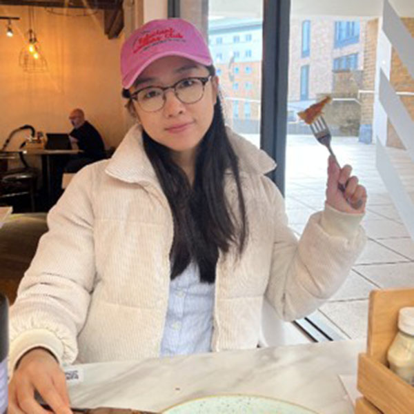 Cath smiling enjoying her pancake brunch in Deli, a restaurant on campus.