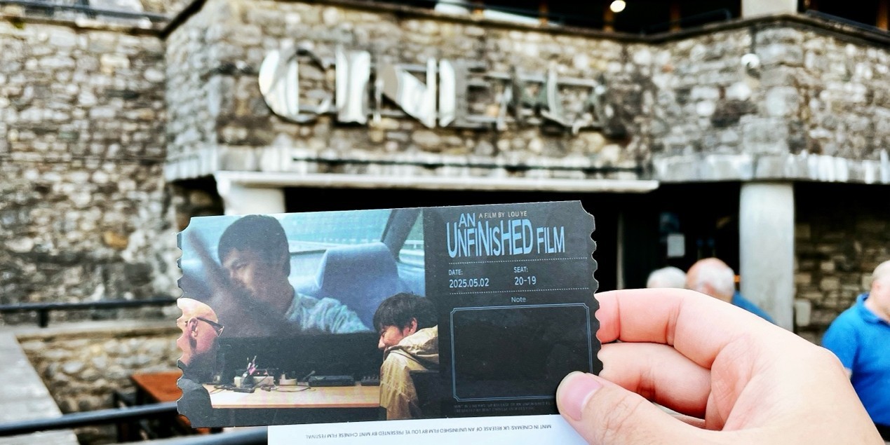 A person holding a film ticket outside the Brewery Arts Centre.