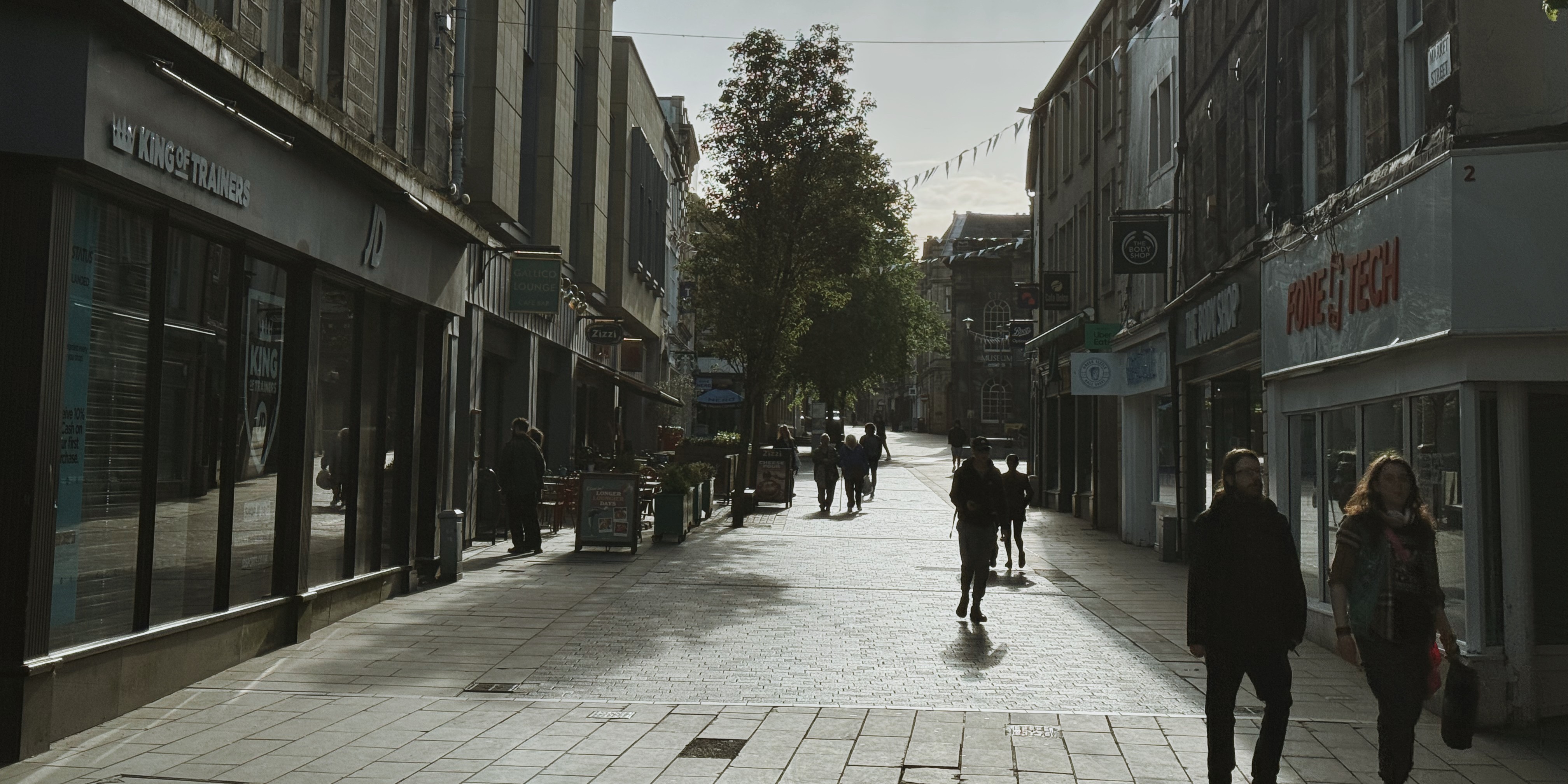People walking along the street in Lancaster town centre under a nice weather. 