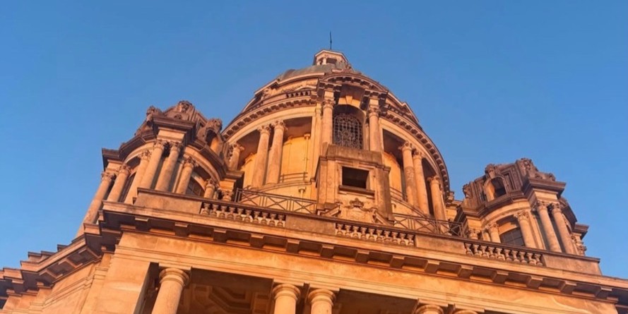 An ant view of the Ashton Memorial with the orange sunset shone on it.