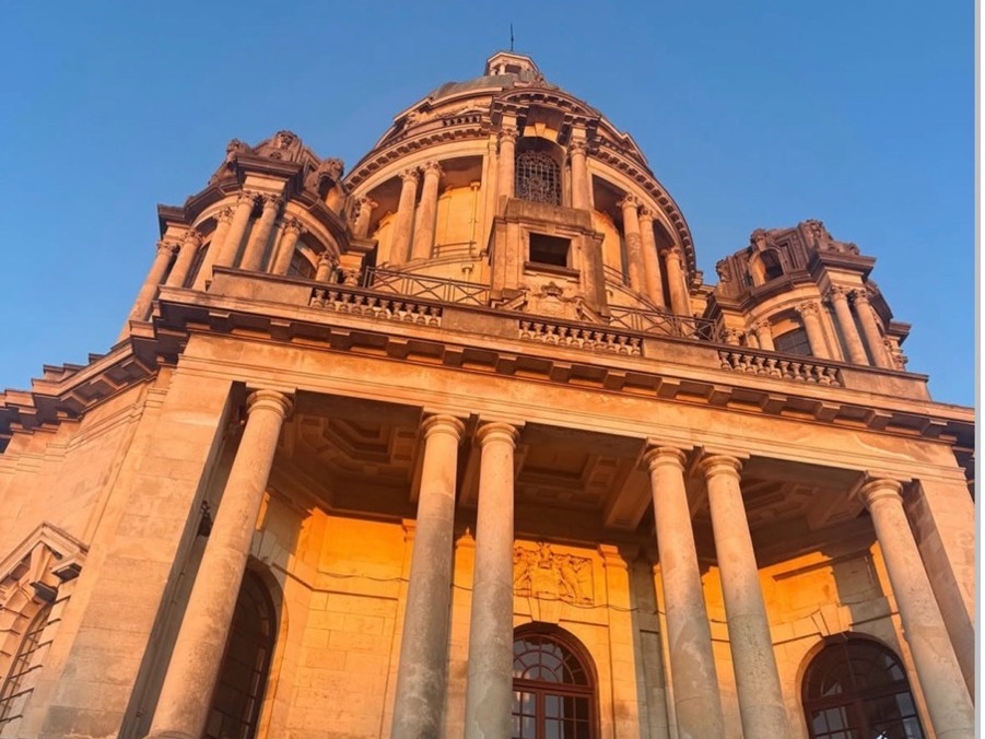 An ant view of the Ashton Memorial with the orange sunset shone on it.