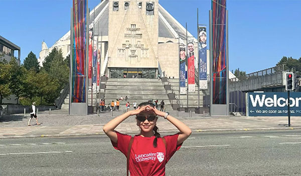 A person standing in front of Liverpool Metropolitan Cathedral. 