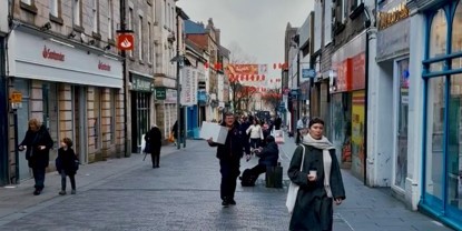 A street in Lancaster town centre full of Chinese New Year decorations and with people walking around. 