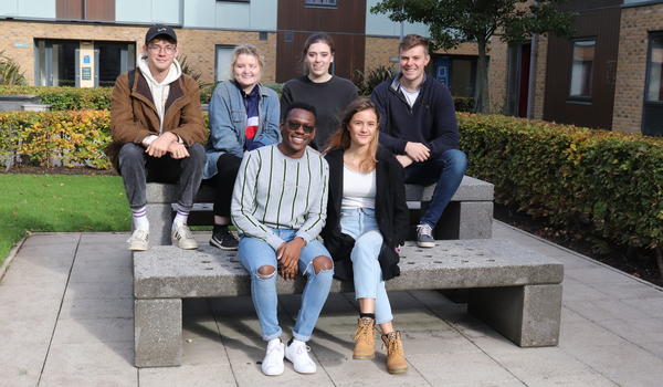 A group of six students sitting on a bench