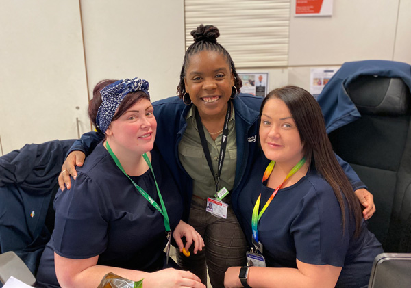 A group of three female staff in a staffroom