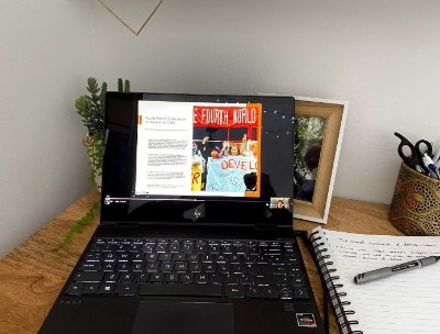 Laptop on a desk with pen and notepad to the side