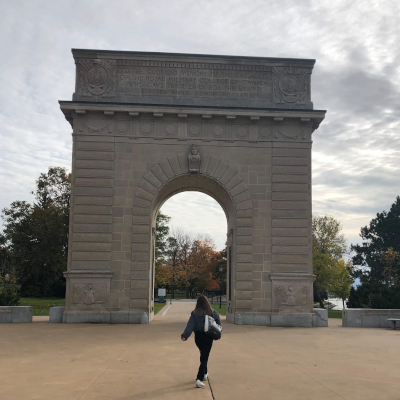 Digital content ambassador Sonia walking in front of stone arch