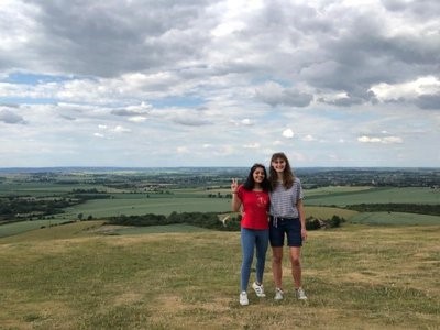Maria and her friend standing together in the countryside