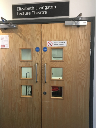 Double wooden doors and a sign saying 