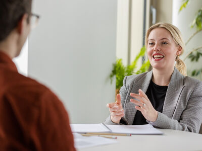 Two members of staff at table having a discussion