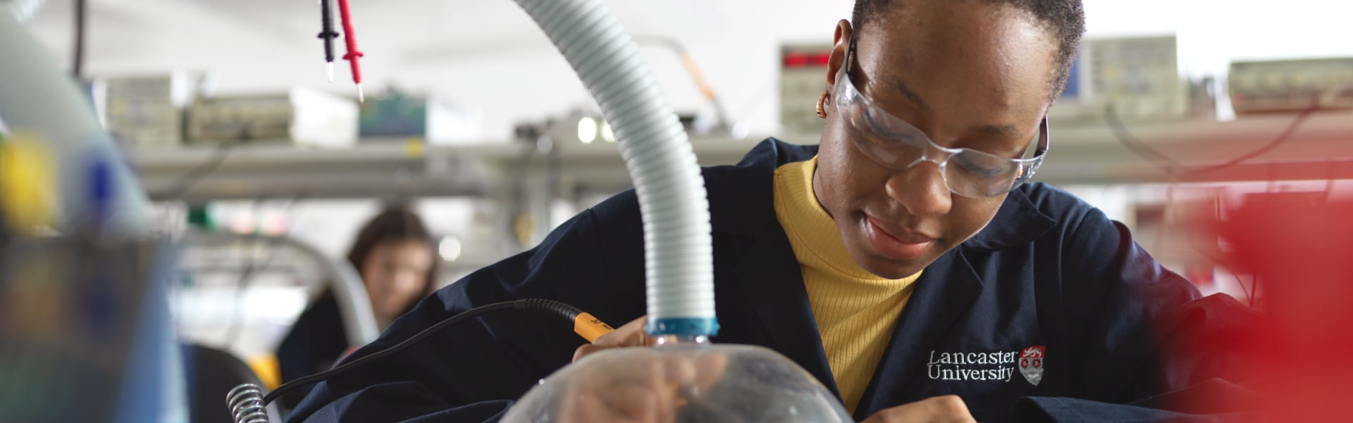 A student works intently in a laboratory with a soldering iron.