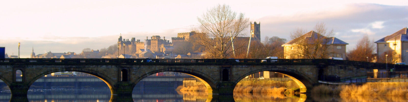 A long shot of Lancaster in the sunshine with a bridge in the foreground.