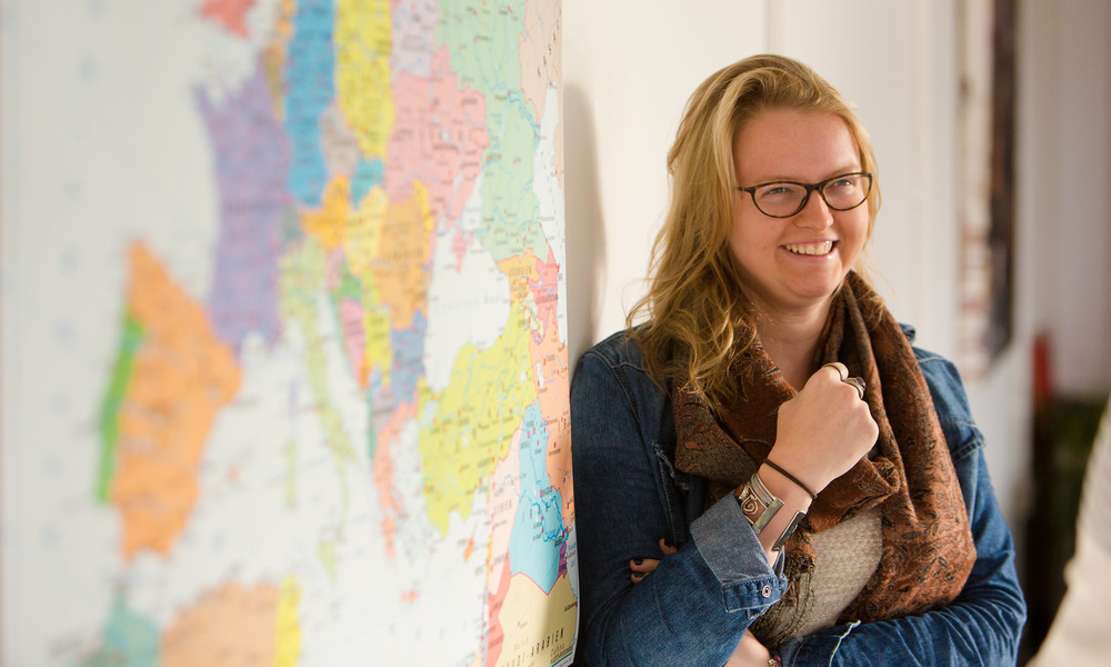 Lecturer stood next to a map of the world on the wall