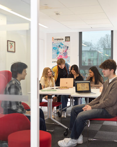 Group of students working in groups with laptops open