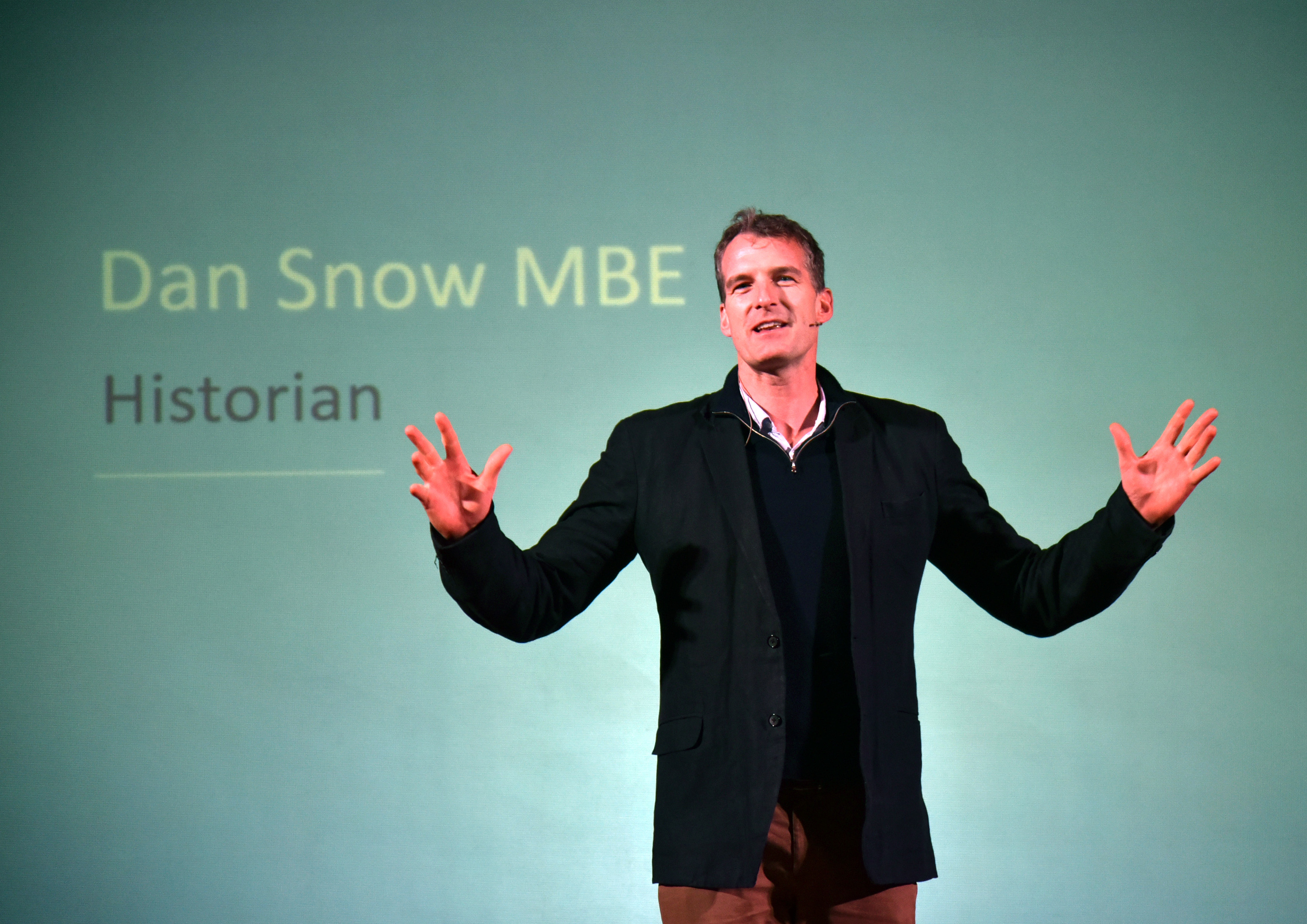Dan Snow standing in front of a screen with his name on.