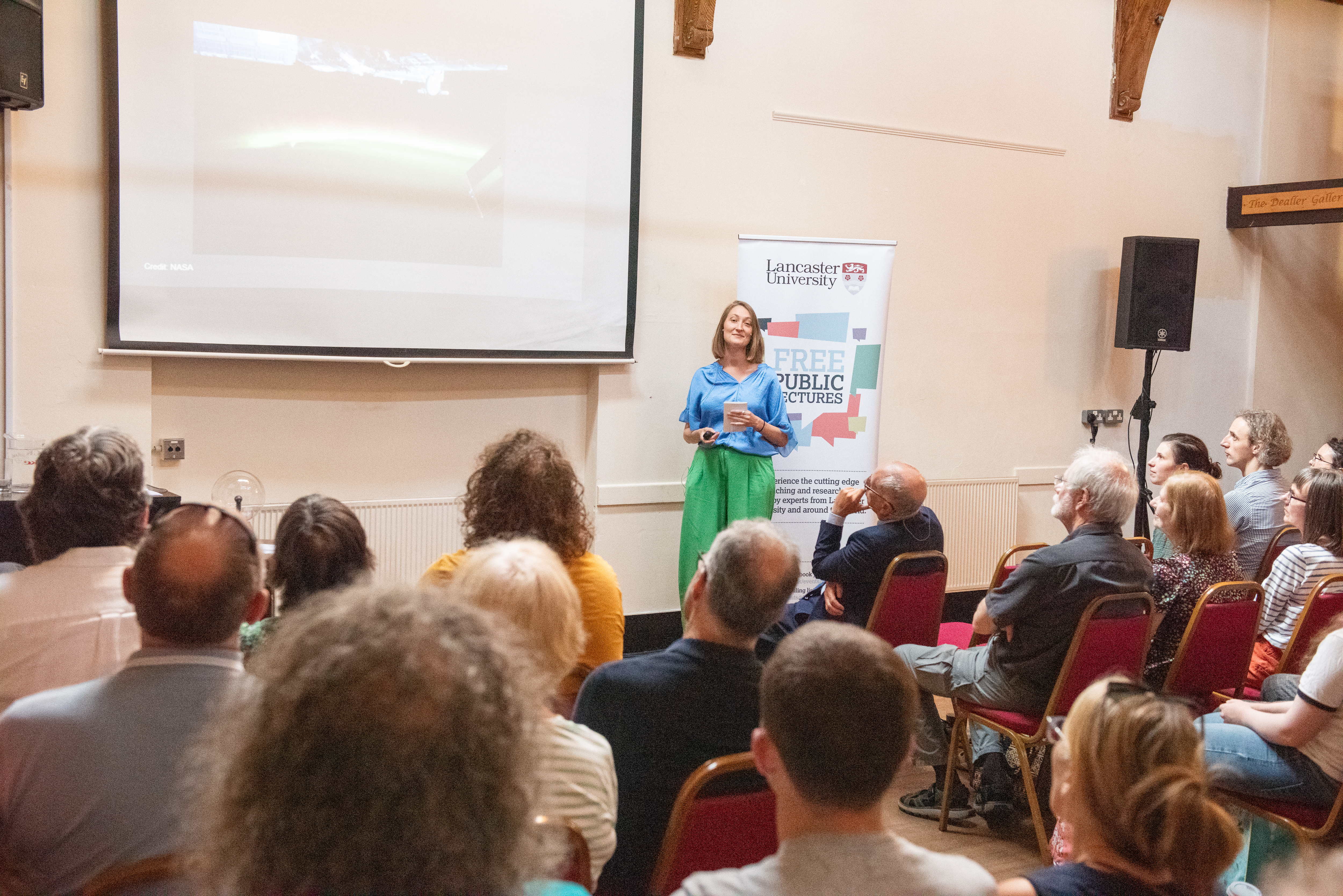 Maria Walach standing in front of an audience presenting her lecture.