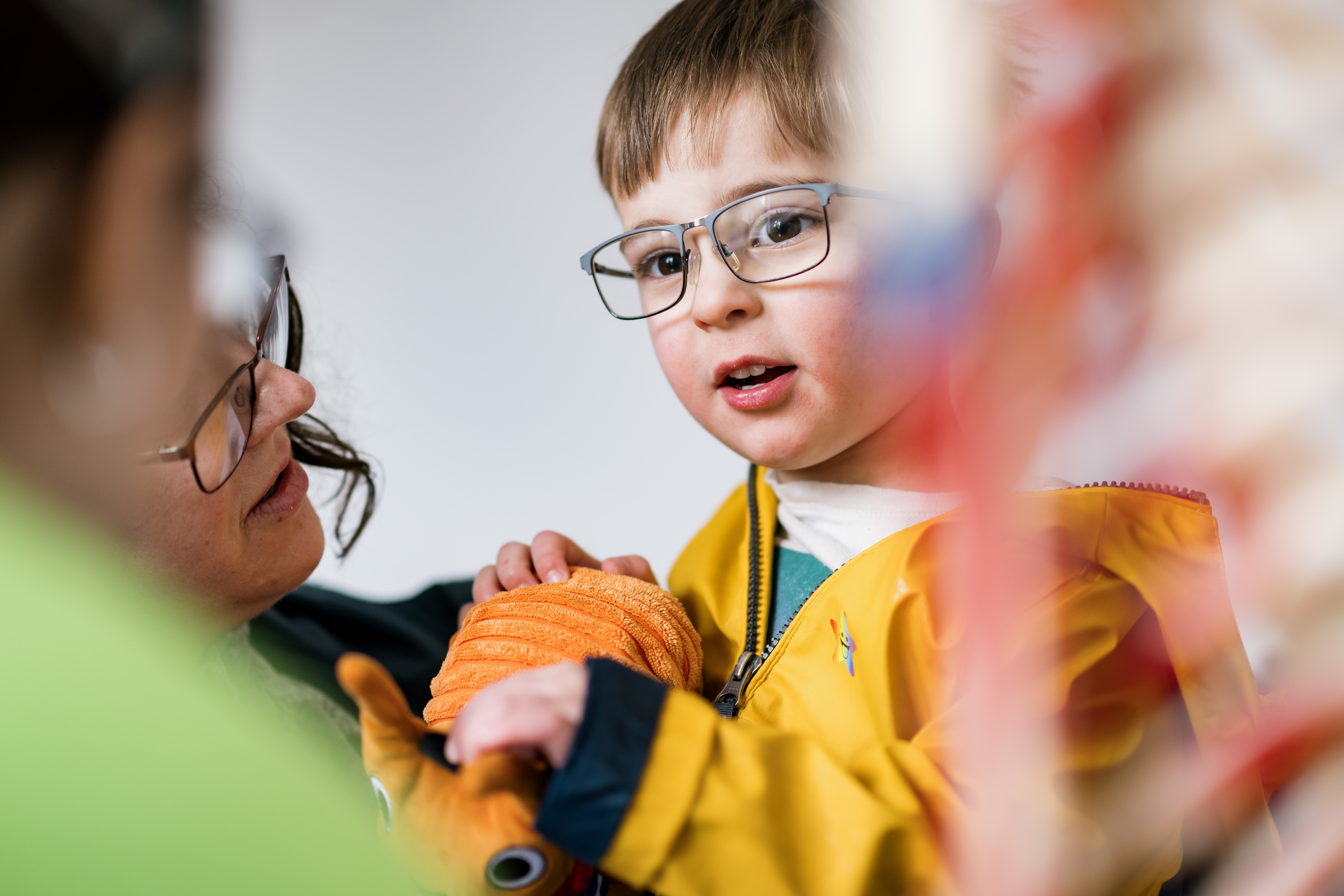 a child in a yellow coat and glasses