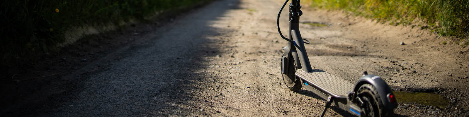 A close up of an electric scooter on a rough country path